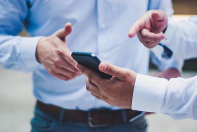Digitale Supply Chain im Anlagenbau: Zwei Männer mit Smartphone und App