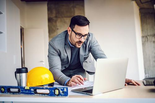 digitale Baudokumentation, Mann im Baustellenbüro digitale Baudokumentation, Mann erstellt auf Knopfdruck Dokument im Baustellenbüro